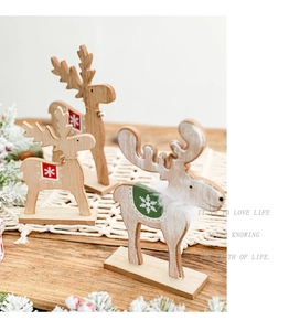 Detail of wooden Christmas reindeer figurines with snowflake patterns and natural wood grain