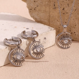 Detail of silver crescent moon and evil eye jewelry set with sparkling crystals