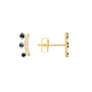 Detail of gold crown earrings with blue gemstones and white pavé crystals