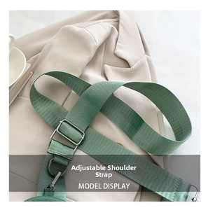 Detail of adjustable green nylon shoulder strap with silver metal buckle on a casual bag