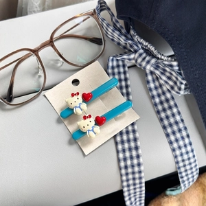 Details von blauen Hello Kitty Acryl-Haarspangen mit roten Herzen auf Displaykarte