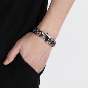 Détail d'un bracelet gourmette texturé vintage avec fermoir mousqueton sur un poignet