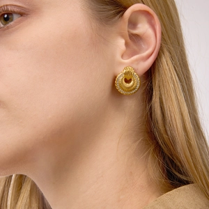 Detail of gold-plated door knocker earrings with radial texture and zircon accents