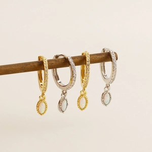 Detailed view of gold and silver hoop earrings featuring oval opal pendants and zircon