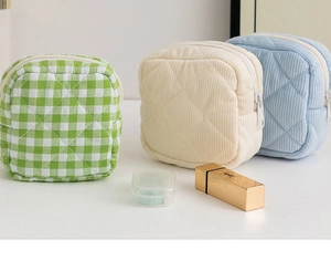 Close-up of quilted corduroy sanitary pad pouches in green plaid and pastel colors