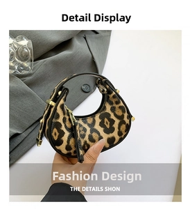 Macro detail of fashionable leopard print mini hobo bag with gold zipper and metal hardware