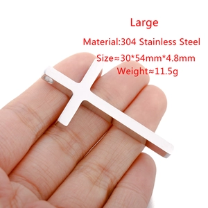 Detailed view of a large polished 304 stainless steel cross pendant held in hand