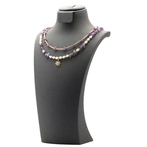 Detail of layered necklace with purple gravel, freshwater pearls and golden sun pendant