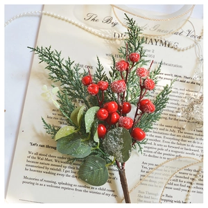 Macro shot of artificial red berry pine branches with snow effect on vintage paper