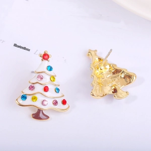 Macro view of Christmas tree earrings with white enamel and colorful rhinestones