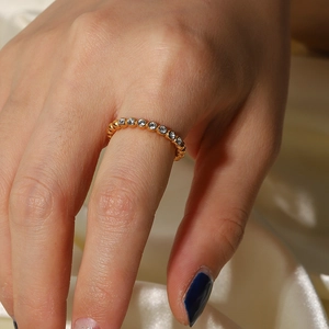 Detail view of 18K gold plated ring featuring cubic zirconia and beaded edge texture