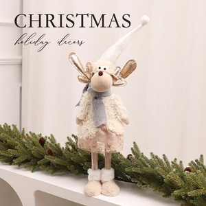 Statuetta di renna di Natale in peluche con corna dorate su scaffale bianco e rami di pino