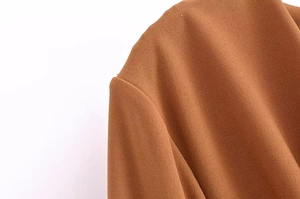 Detailed macro shot of the elegant camel dress showing premium twill fabric texture
