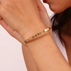 Detail showing an 18K gold plated stainless steel bangle with sparkling cubic zirconia