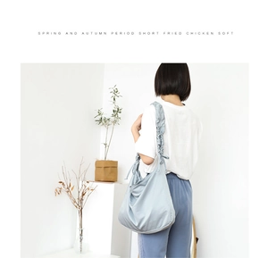 Lifestyle view of a large light blue canvas tote bag on a model in a minimalist setting