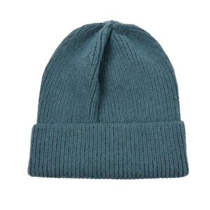 Detail of dark teal beanie featuring a chunky ribbed knit texture and warm fuzzy material