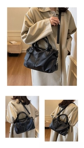 Detail of black lychee grain leather Boston bag with gold hardware and dual handles