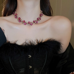 Macro detail of gold flower necklace featuring purple gemstones and sparkling crystals