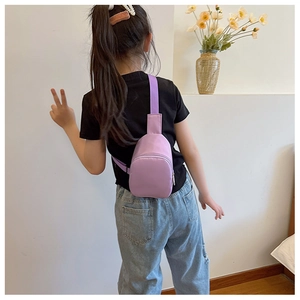Rear view of child wearing purple nylon sling bag with adjustable strap in casual setting