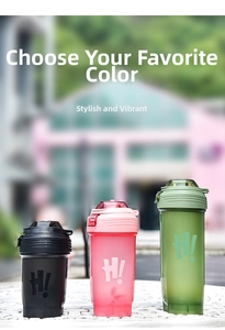 Three gradient plastic fitness shaker bottles in black pink and green on a marble table