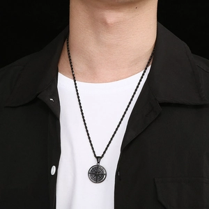 Gros plan d'un collier pendentif boussole noir sur un modèle montrant les points cardinaux