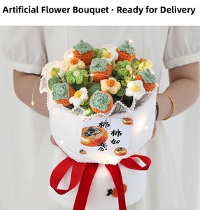 Detail of knitted sunflower and persimmon bouquet with LED lights and red velvet ribbon
