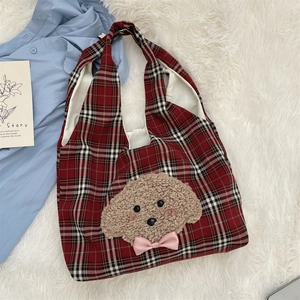 Detail of red and black plaid tote bag with plush puppy embroidery and pink bow