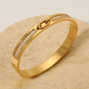 Polished gold stainless steel bangle with inlaid baguette crystals and chain link detail