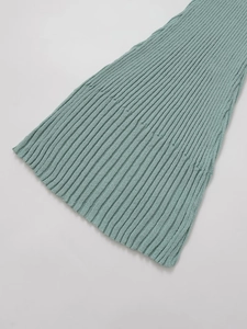 Detail van de mintgroene ribgebreide zoom met fijne stiksels en textuur van jurk