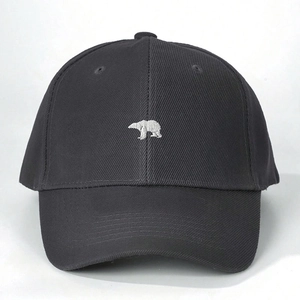 Detailed close-up of white polar bear embroidery on dark grey cotton baseball cap