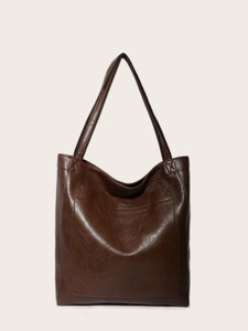 Détail d'un cabas vintage en cuir marron montrant la couture de la poche et la texture