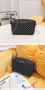 Detail of grey geometric pattern crossbody bag with gold chain and metal logo plate