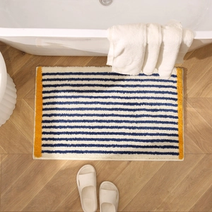 Thick plush rectangular blue and white striped rug on wooden floor with yellow border