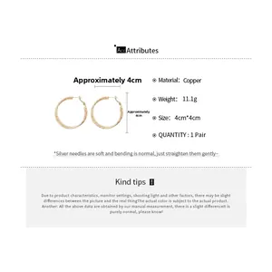 Detail view of 4cm gold hoop earrings with spiral texture and copper material specs