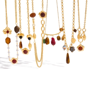 Detail of vintage gold necklaces with resin charms, pearls and red agate pendants