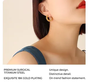 Close-up of 18k gold plated surgical titanium steel C-shape twisted hoop earrings on model