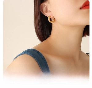 Close-up of 18k gold plated surgical titanium steel C-shape twisted hoop earrings on model