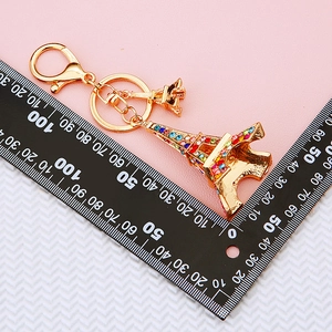 Golden Eiffel Tower keychain with colorful rhinestones measured with a ruler for size