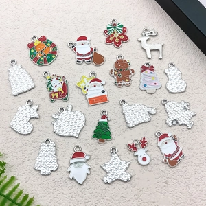 Flat lay of colorful enamel Christmas charms including Santa, elk, and trees for DIY jewelry