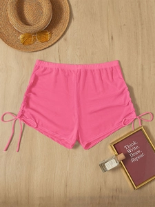 Detail view of pink sheer mesh beach shorts with adjustable drawstring side ties