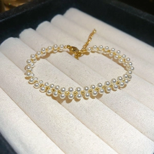 Close-up of double-layer pearl bracelet with gold lobster clasp and adjustable chain