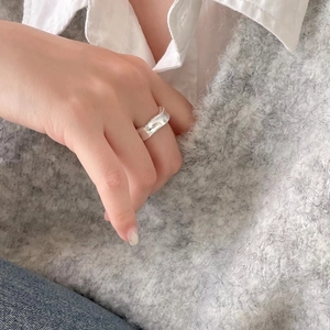 Elegant 925 sterling silver ring with irregular wave texture worn on finger by a model