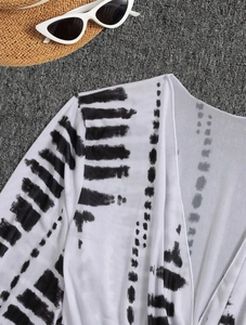 Close-up of lightweight tie-dye printed beach cover-up with summer fashion accessories