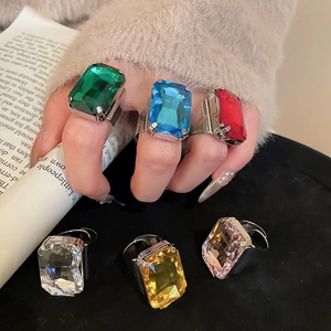 Detail of colorful rectangular gemstones in prong settings on silver rings