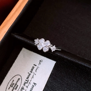 Macro de la bague trèfle sertie de zircons dans son écrin en bois de luxe