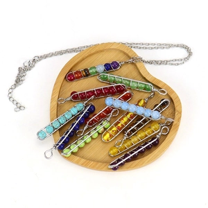 Handmade 7 Chakra energy stone necklace with colorful beaded U-shaped pendants on wood tray