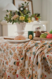 Detail shot of cotton linen Christmas tablecloth featuring festive gingerbread man patterns