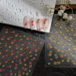Detail of DIY koi fish nail art stickers with gold accents on almond nails
