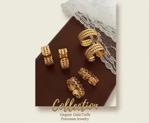 Detailed macro view of gold-plated open rings with leaf and wheat patterns on wood