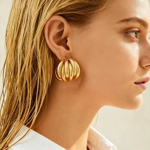 Close-up of golden multi-layer textured geometric hoop earrings on a female model
